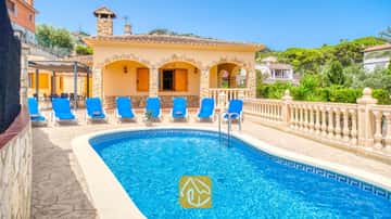 Piscina privada al aire libre de aguas cristalinas, rodeada de tumbonas y una terraza de piedra en Villa Sarai, España.