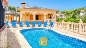 Piscina privada al aire libre de aguas cristalinas, rodeada de tumbonas y una terraza de piedra en Villa Sarai, España.